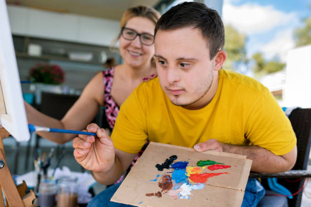 Down Syndrome with occupational therapist doing painting